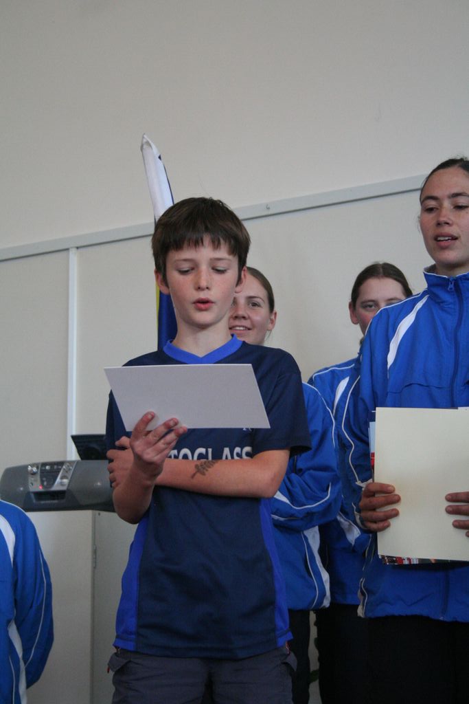 A school representative reads out the plaque for the tree.